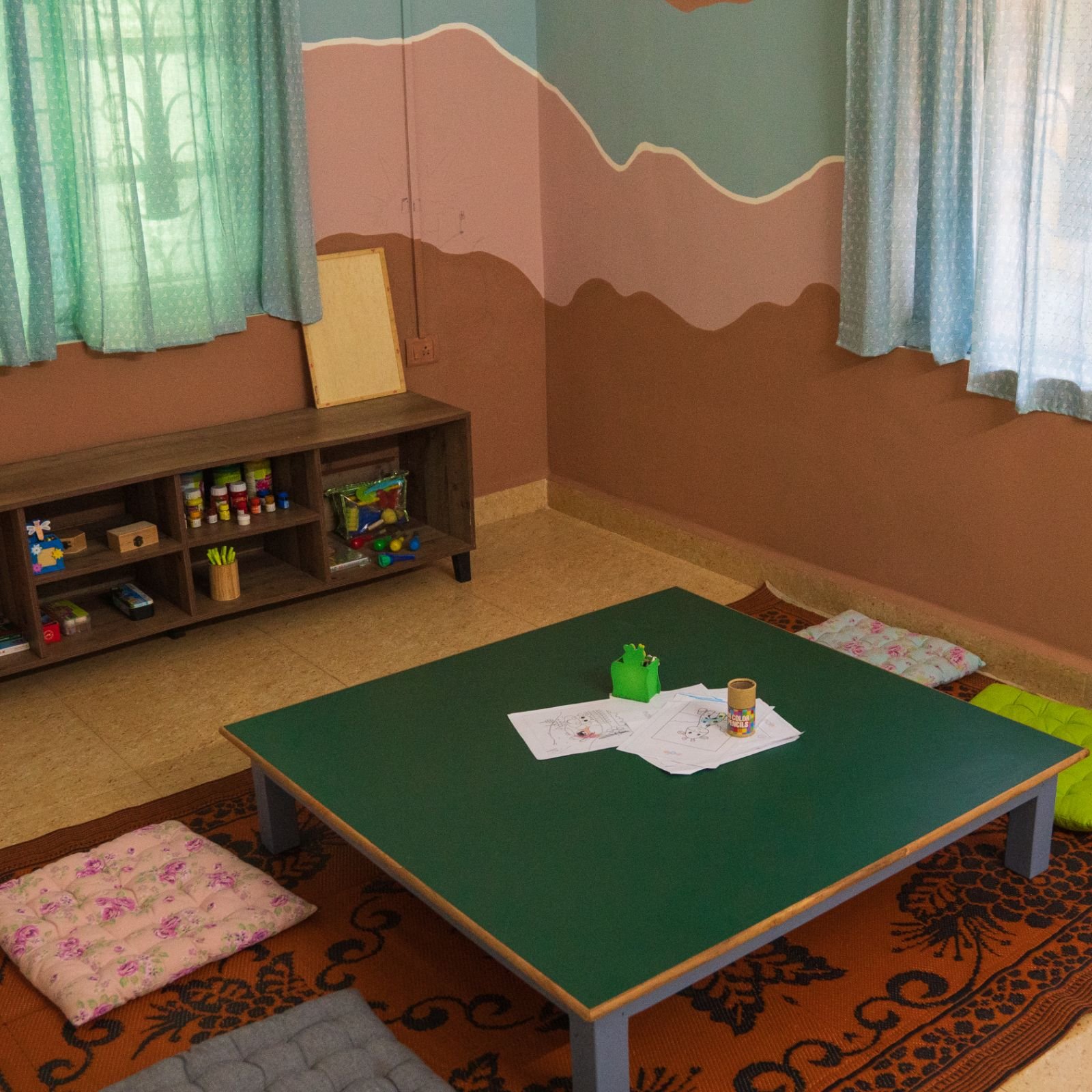 A low classroom activity table at Odo School with a hand-painted mural